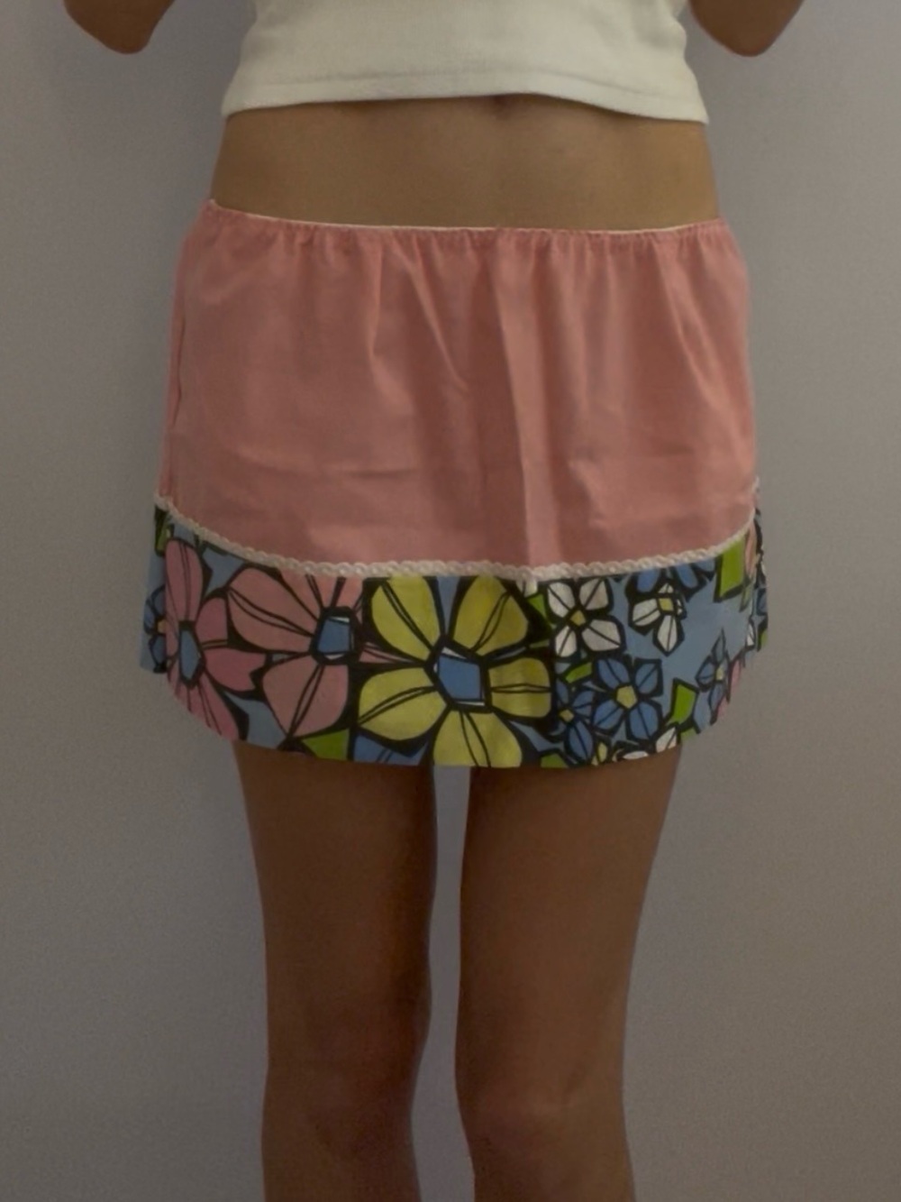Pink vintage mini skirt with white lace trim and floral details